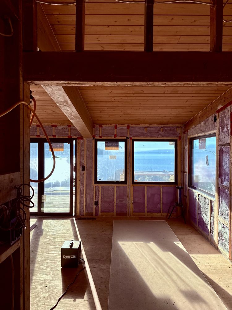 Tongue-and-groove wood ceiling and beams in a room under construction, with ocean views